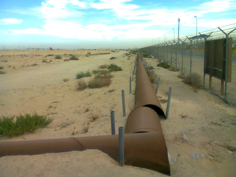 Archive: parallel crude/product oil pipelines snaking across Jubail desert scrub, Saudi Arabia, 3 Dec 2012 (Suresh Babunair, CC BY 3.0). Not the September 2026 East-West (Petroline) drone-strike shut, not Yanbu terminal day-of, not the postponed Oman Gulf–Iran meeting, and not a live Hormuz chokepoint still.