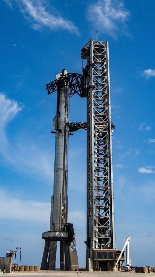 Archive: SpaceX Starship Booster 7 / Ship 24 full stack on the Orbital Launch Mount at Starbase, Boca Chica, Texas, beside the Mechazilla tower — tower peak and Starship nose fully in frame (Jenny Hautmann, CC BY-SA 4.0). Not the 21–22 September 2026 S.D. Texas preliminary-injunction hearing or order, not DOJ/ENRD counsel day-of, not a deed-closing photograph, and not FWS refuge acreage imagery.
