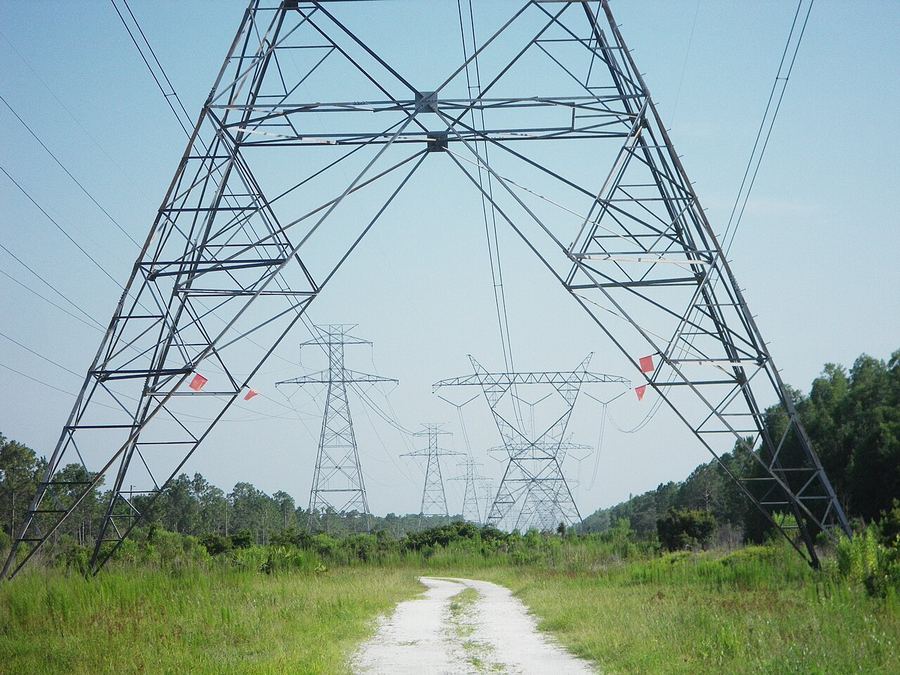 Archive: 230 kV and 500 kV transmission towers along a utility corridor, Pasco County, Florida — Daniel Oines (CC BY 2.0). Not the September 2026 DOE SPARK announcement, not day-of DOE officials, and not a construction-ceremony still.