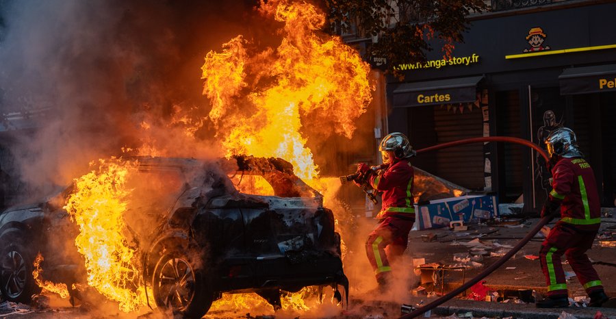 Paris Fire Brigade firefighters hose down a burning car near Place de la République in Paris on October 17.