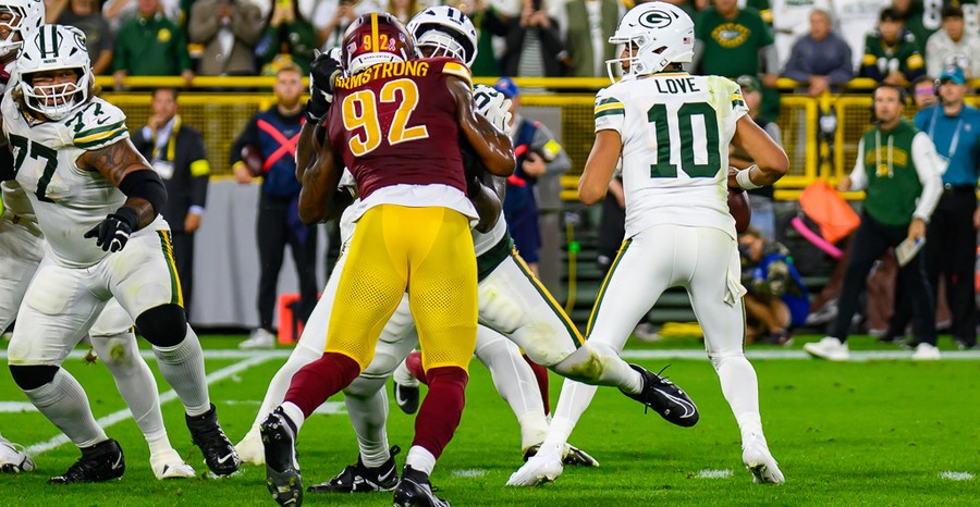 Jordan Love drops back to pass as Washington's Dorance Armstrong pushes into the pocket at Lambeau Field in September 2025.
