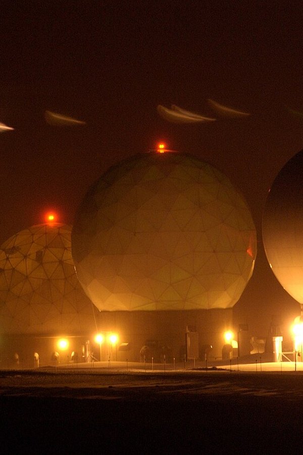 Archive: Night view of geodesic “golf ball” radome covers for satellite dishes at Thule Air Base (now Pituffik Space Base), Greenland — floodlit white domes against dark Arctic sky (U.S. Air Force / Michael Tolzmann, public domain). Not the 22 September 2026 New York signing ceremony, not Trump/Frederiksen/Nielsen day-of photography, not UNGA podium stills, and not a 2026 construction start.